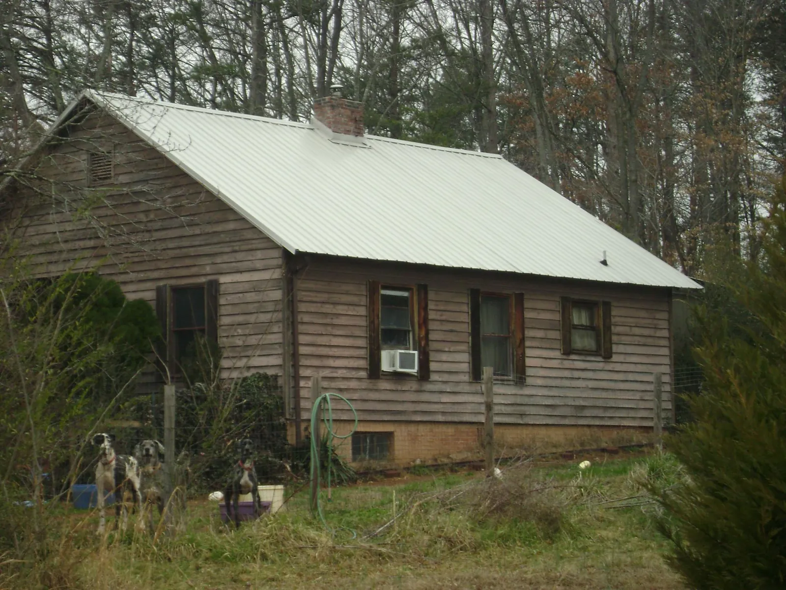 White metal roof on an old wood sided farmhouse, from a Metal Roof Installation job in Hills