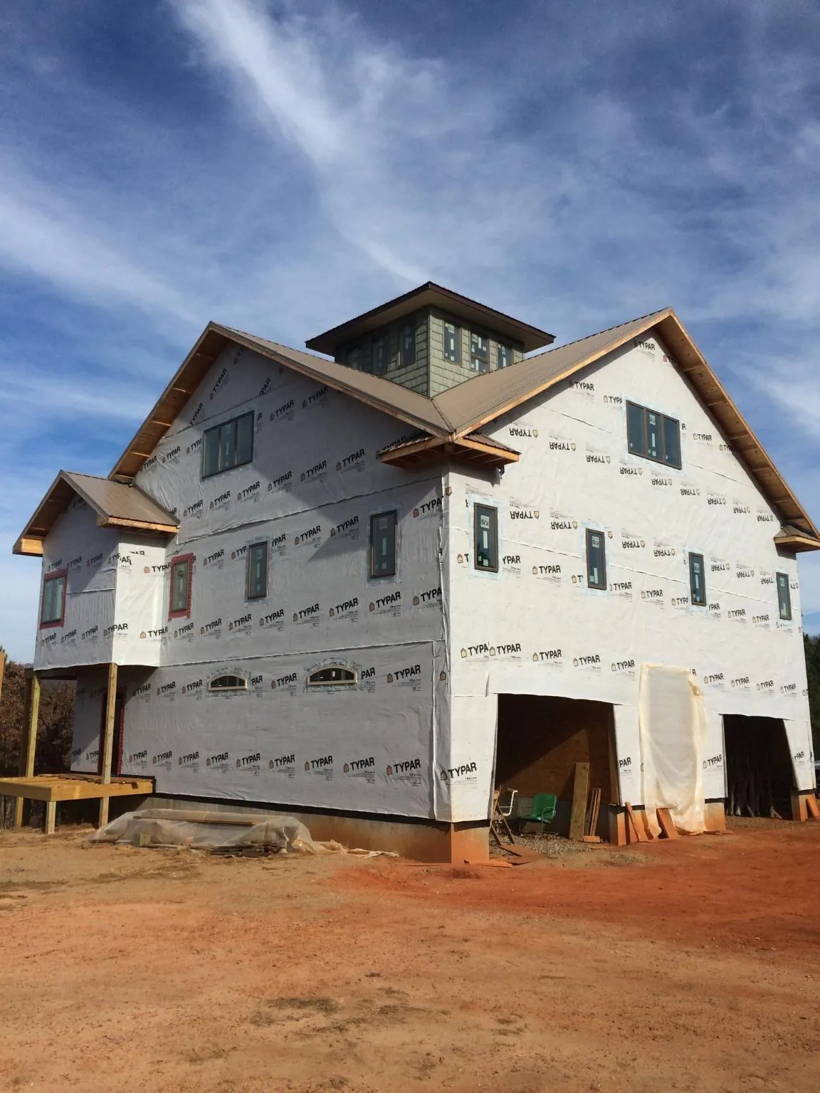 New two story house under construction with a cupola and gabled roofs in Hills